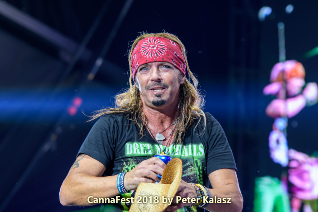 Bret Michaels holding his cowboy hat while looking at the crowd during a live performance.